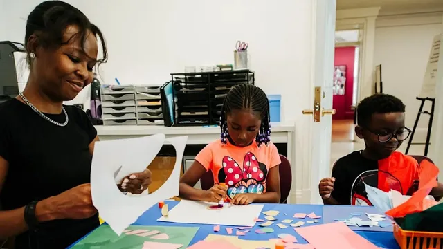 Woman and two children smiling and working on craft project