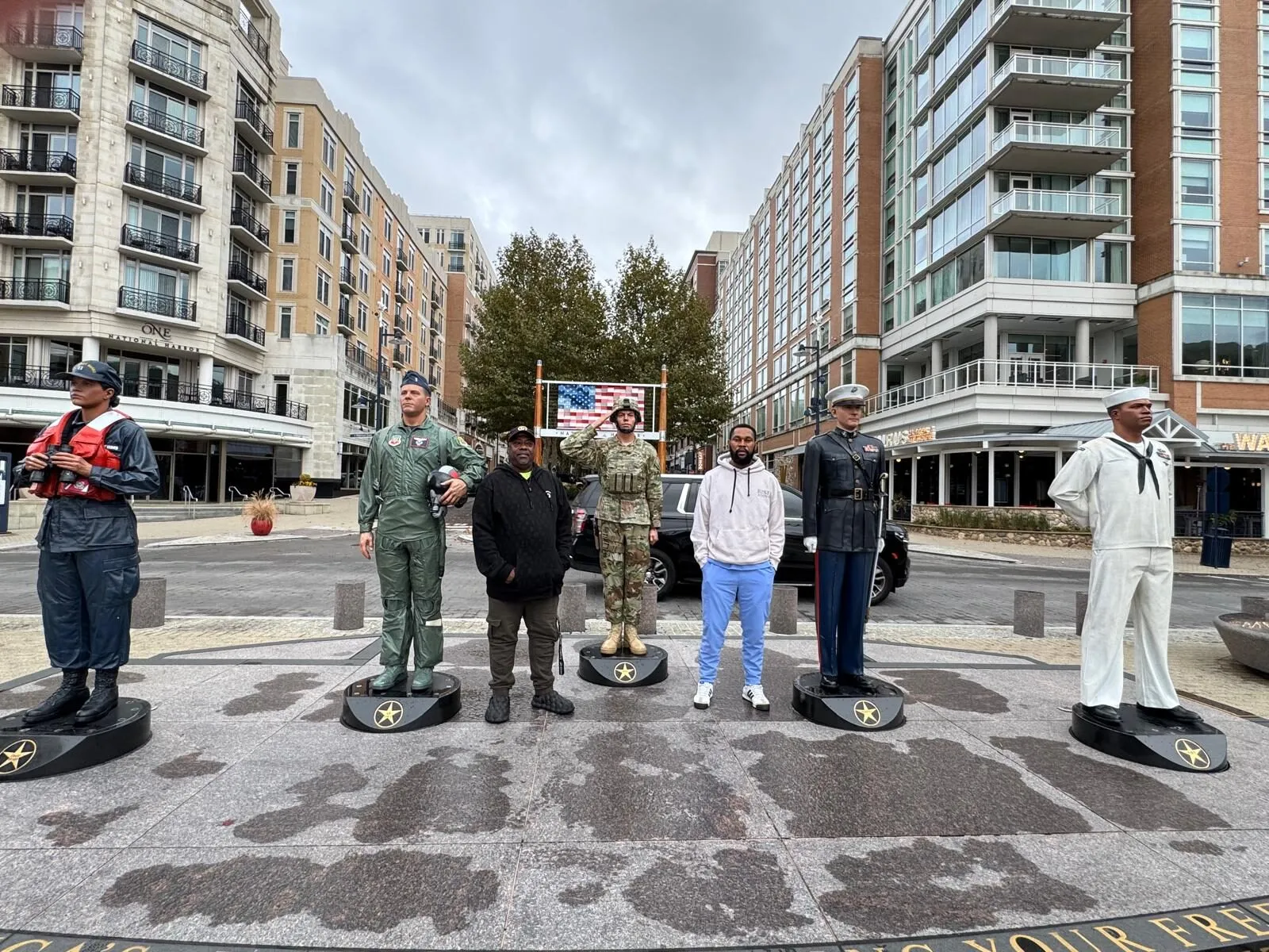 Members of the Mercyland community on an outing at a downtown plaza lined with statues of service members.